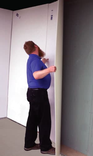 Technician installing GLASBOND FRP wall panel - lightweight fiberglass panel for clean, durable interior surfaces.